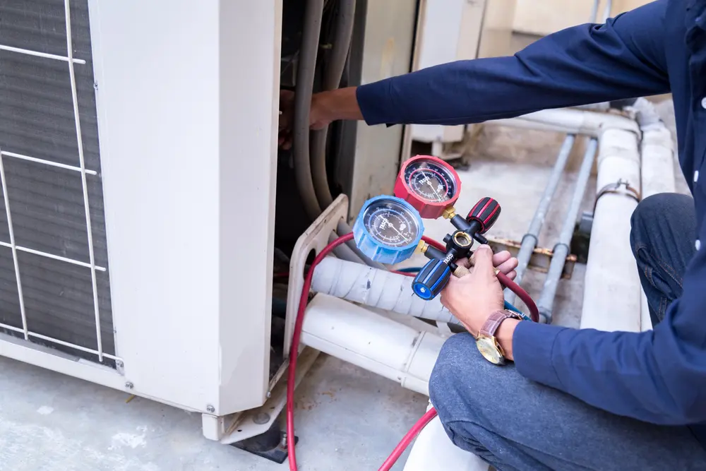Horizon Services technician inspecting an AC condenser during a seasonal tune-up